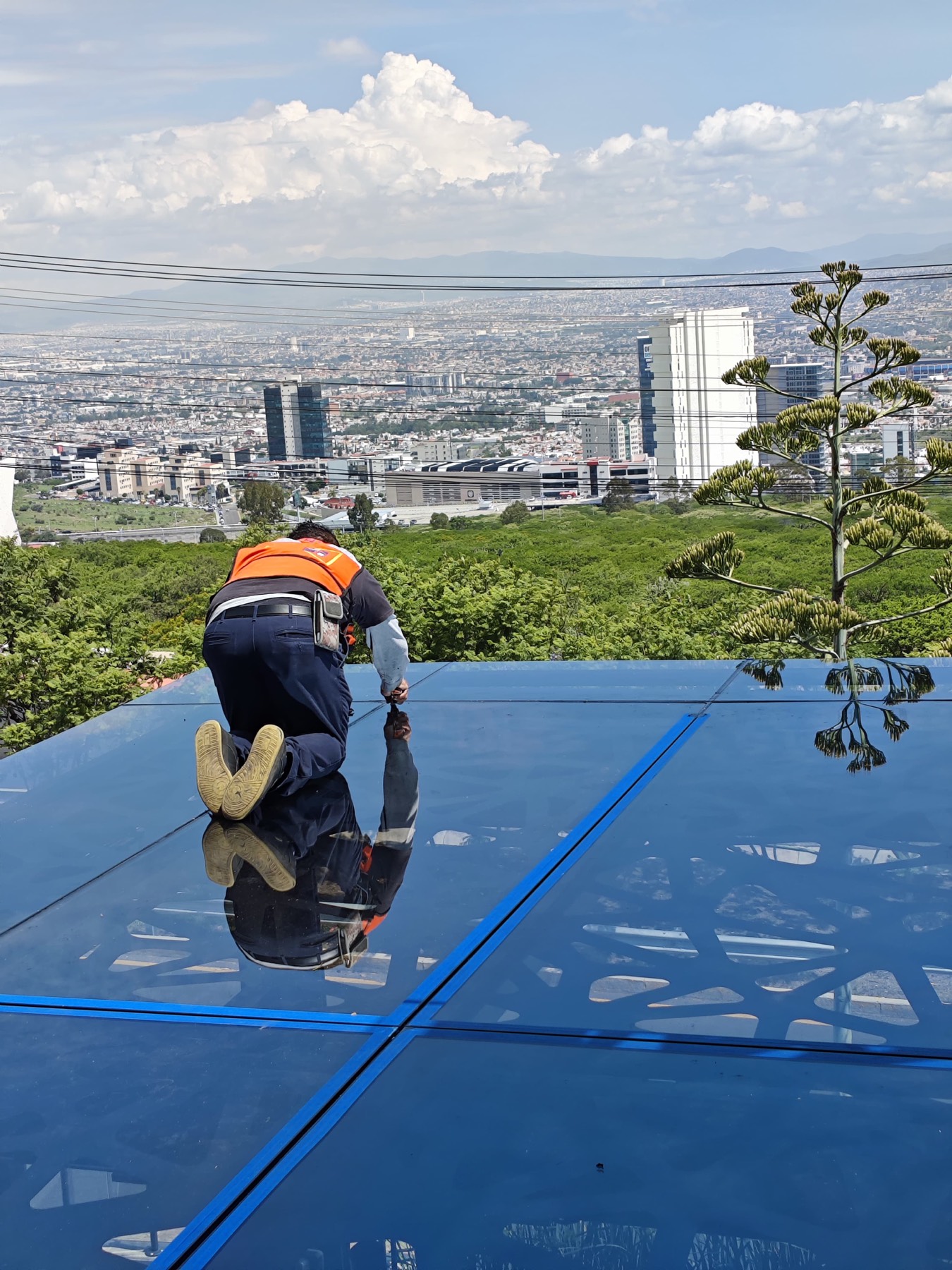 Instalador de Euroventanas sellando un tragaluz con vista a Querétaro