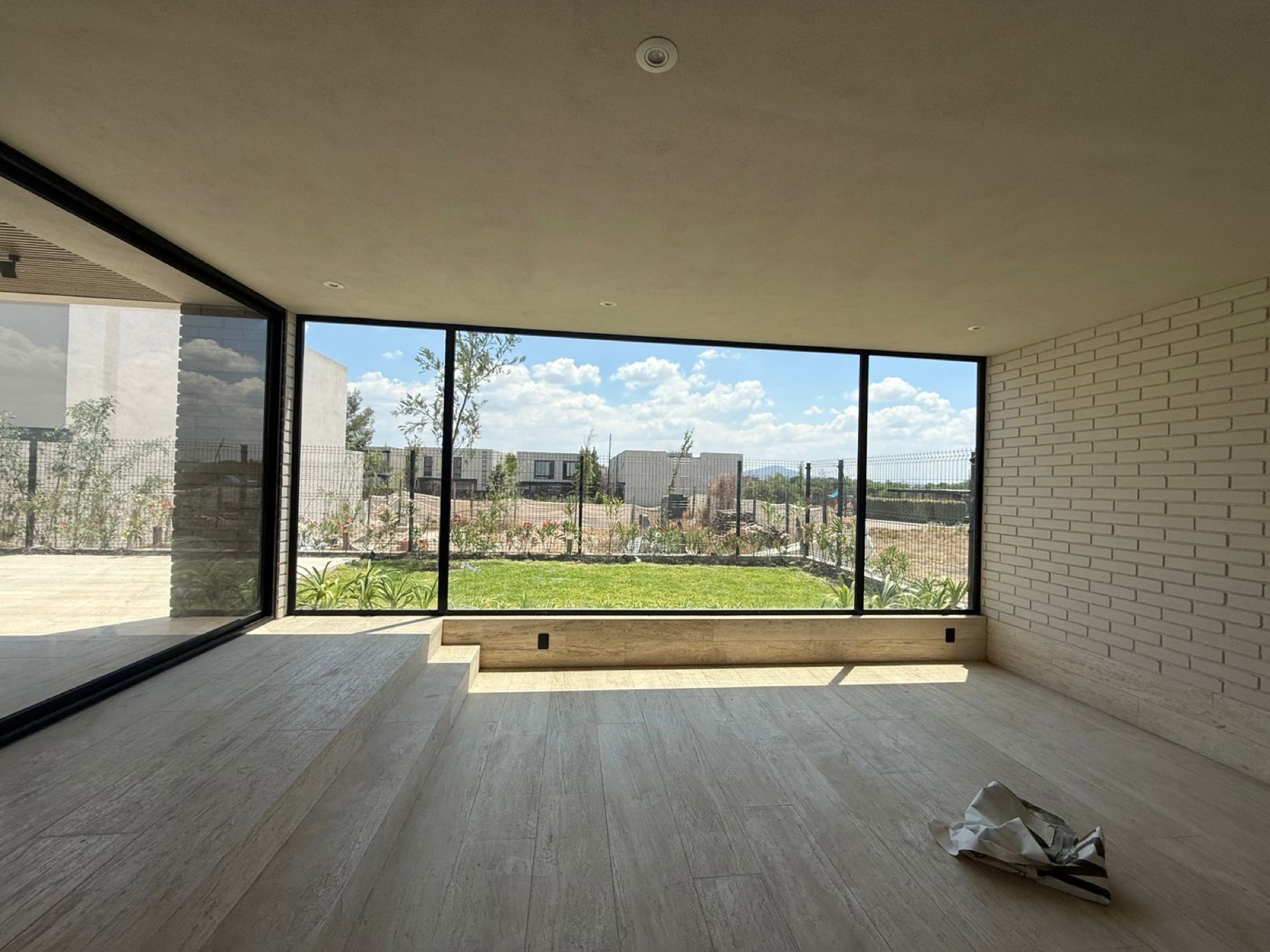 Muro de vidrio de piso a techo con vista al jardín en una residencia de Querétaro