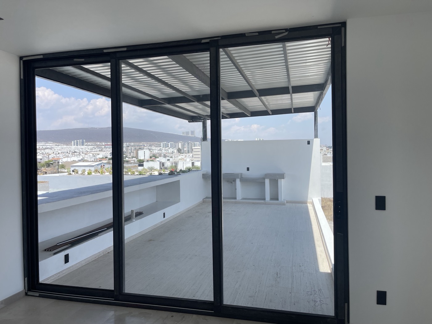 Puerta corrediza de aluminio de tres paneles con vista a Querétaro